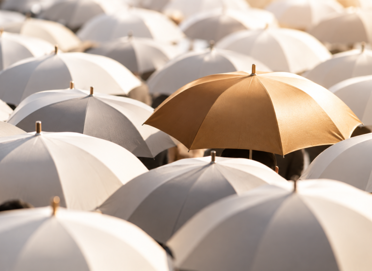 A distinctive golden umbrella standing out among a crowd of white umbrellas, symbolising brand differentiation and competitive advantage.